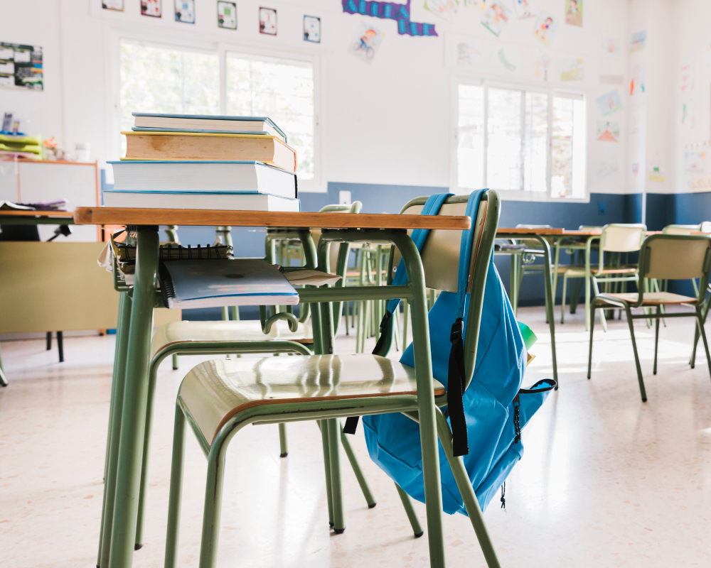 empty classroom desk backpack