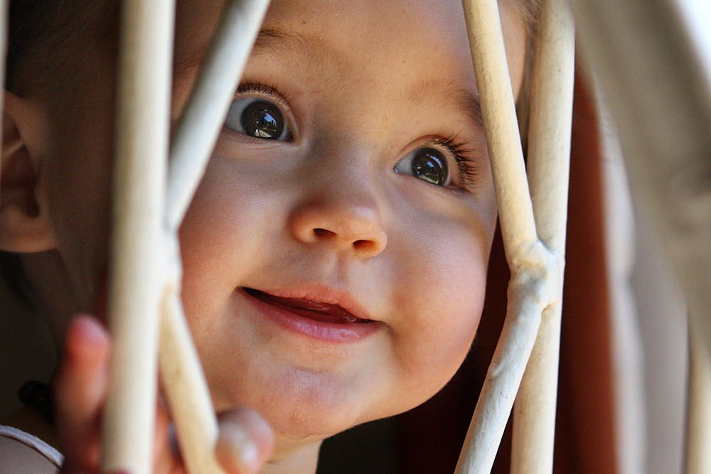 Kid behind bars of fence