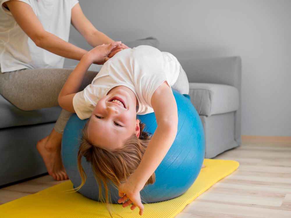 Child smiling on yoga ball